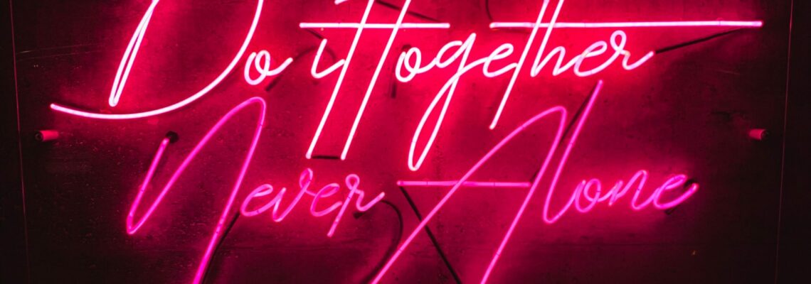 Pink neon on a black background. Text reads, "Do it together, never alone."